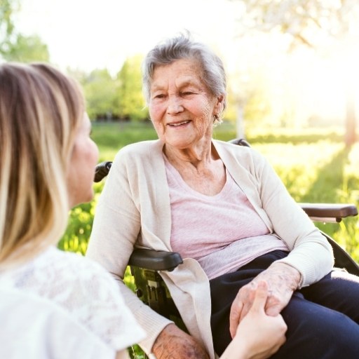 Herzliches Gespräch im Garten zwischen älterer Dame und Besucherin